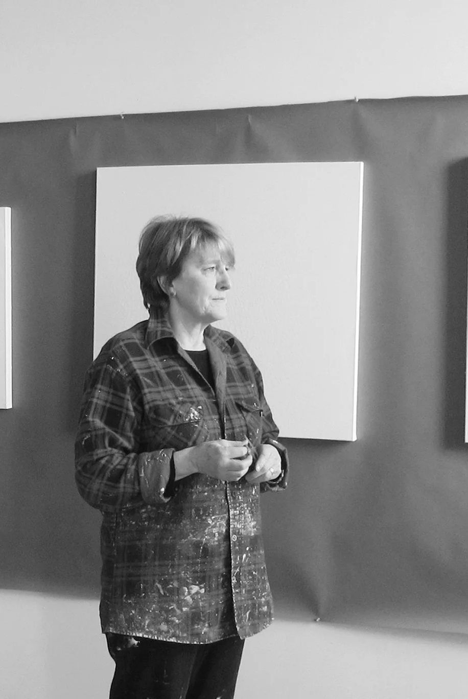 Judy Child in the gallery with her white paintings